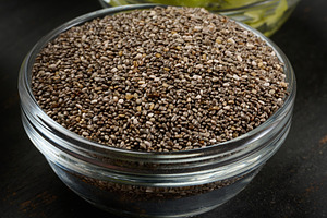 Clear glass bowl filled with dry chia seeds, top view, a Food & Drink Photo by ndanko
