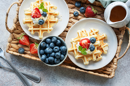 Freshly baked waffles with strawberries and blueberries, a Food & Drink Photo by Olena Rudo