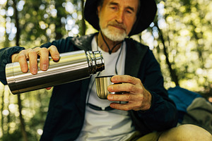 Senior male tourist pouring coffee, a Person Photo by Artem Varnitsin