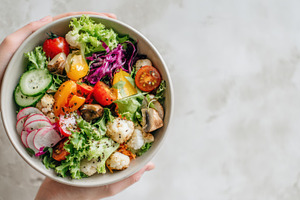 Fresh salad in a bowl held by hands, a Photo by Beautiful things