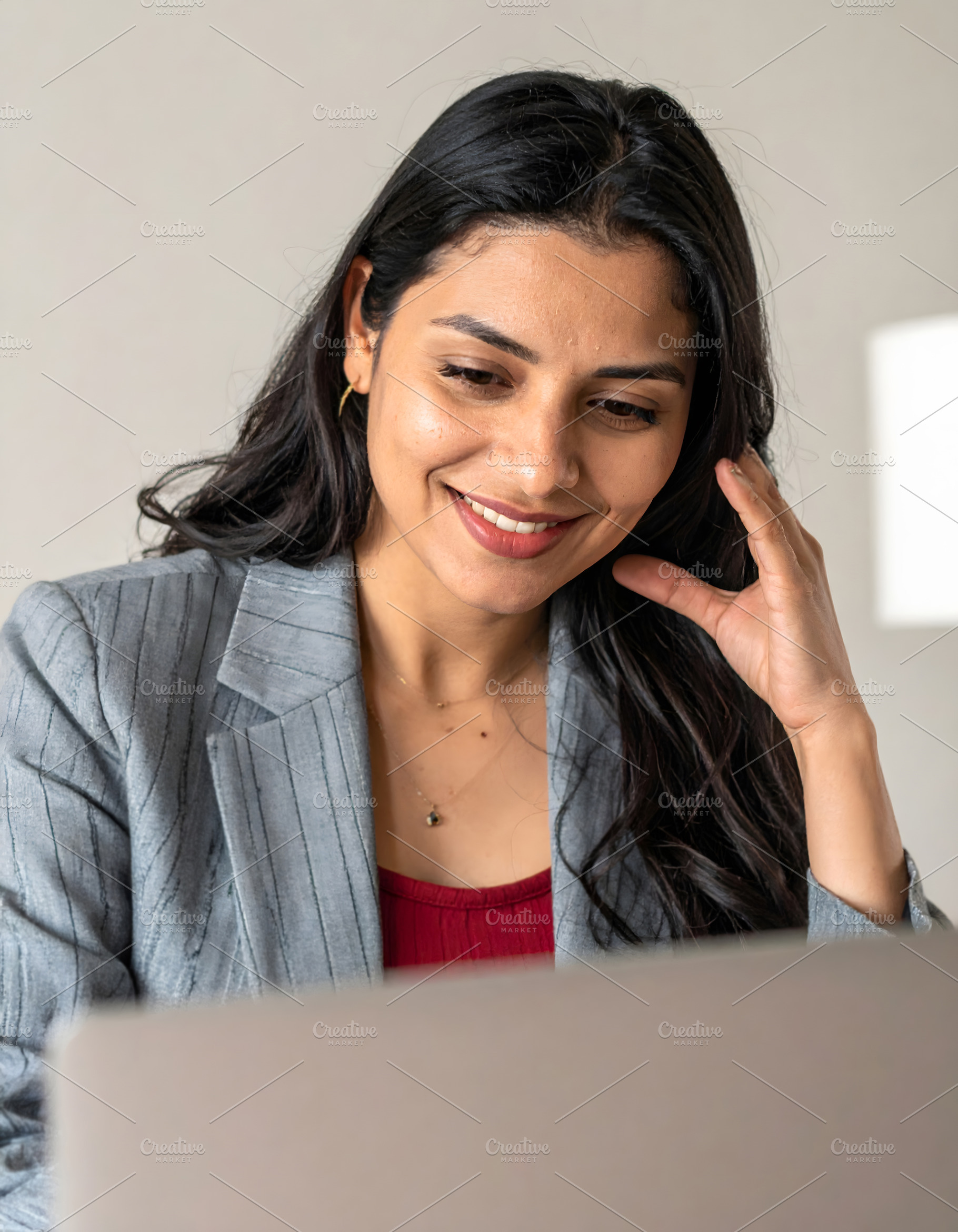 Businesswoman smiling while working on laptop in office, a Person Photo by GoodGoods