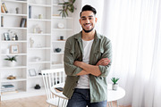 Handsome Young Arab Guy Standing With Folded Arms Near Desk At Home, a Photo by Prostock-Studio (Thumbnail 2 of 2)