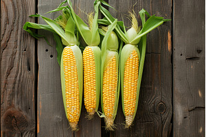 Fresh yellow corn on wooden surface, a Food & Drink Photo by Lermont51