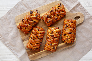 Homemade Maple Pecan Danish Pastry on a wooden board, top view., a Food & Drink Photo by LiudmylaChuhunova