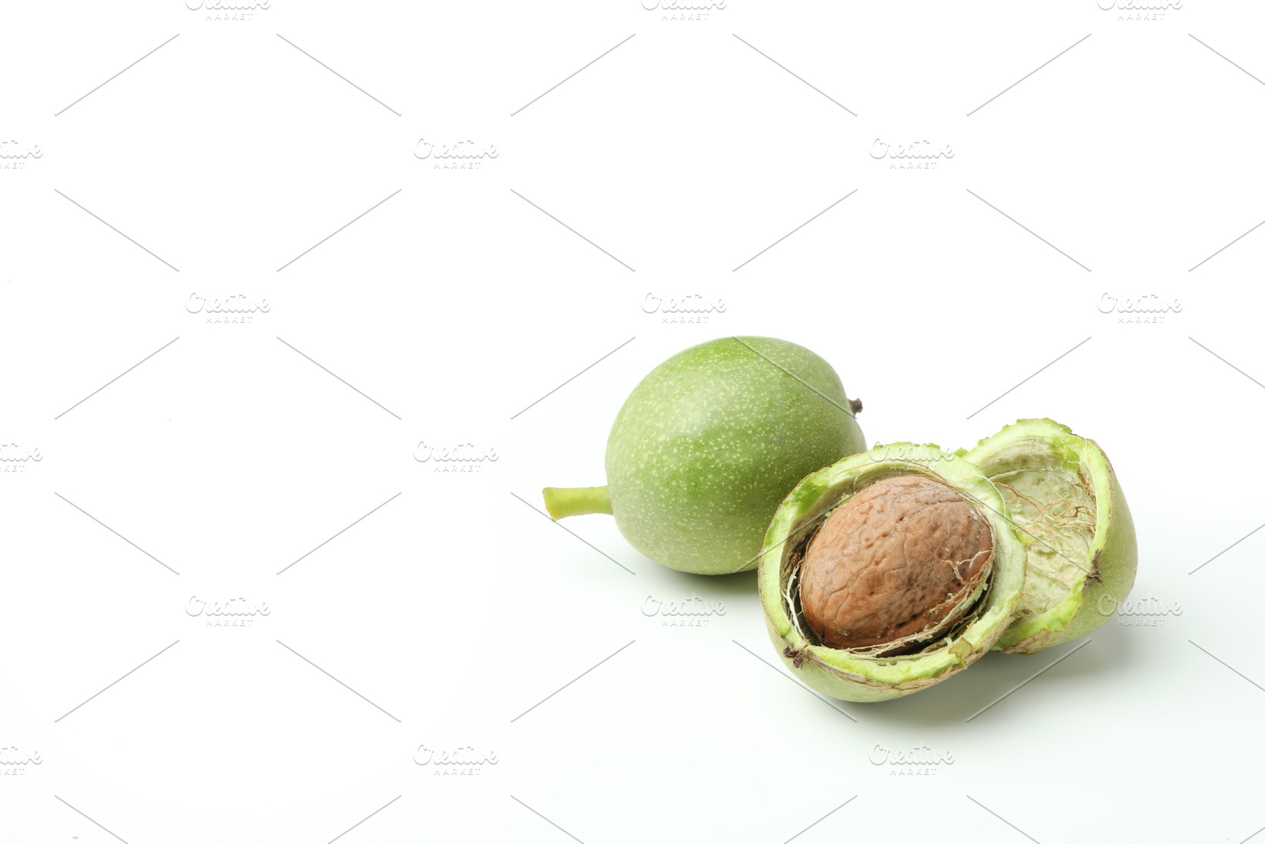 Walnuts with nut peel isolated on white background, a Food & Drink Photo by AtlasStudio
