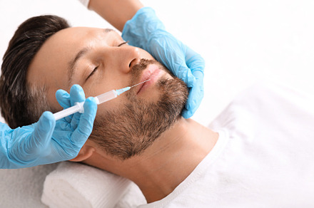 Closeup of bearded man getting nasolabial injection at clinic, a Photo by Prostock-Studio