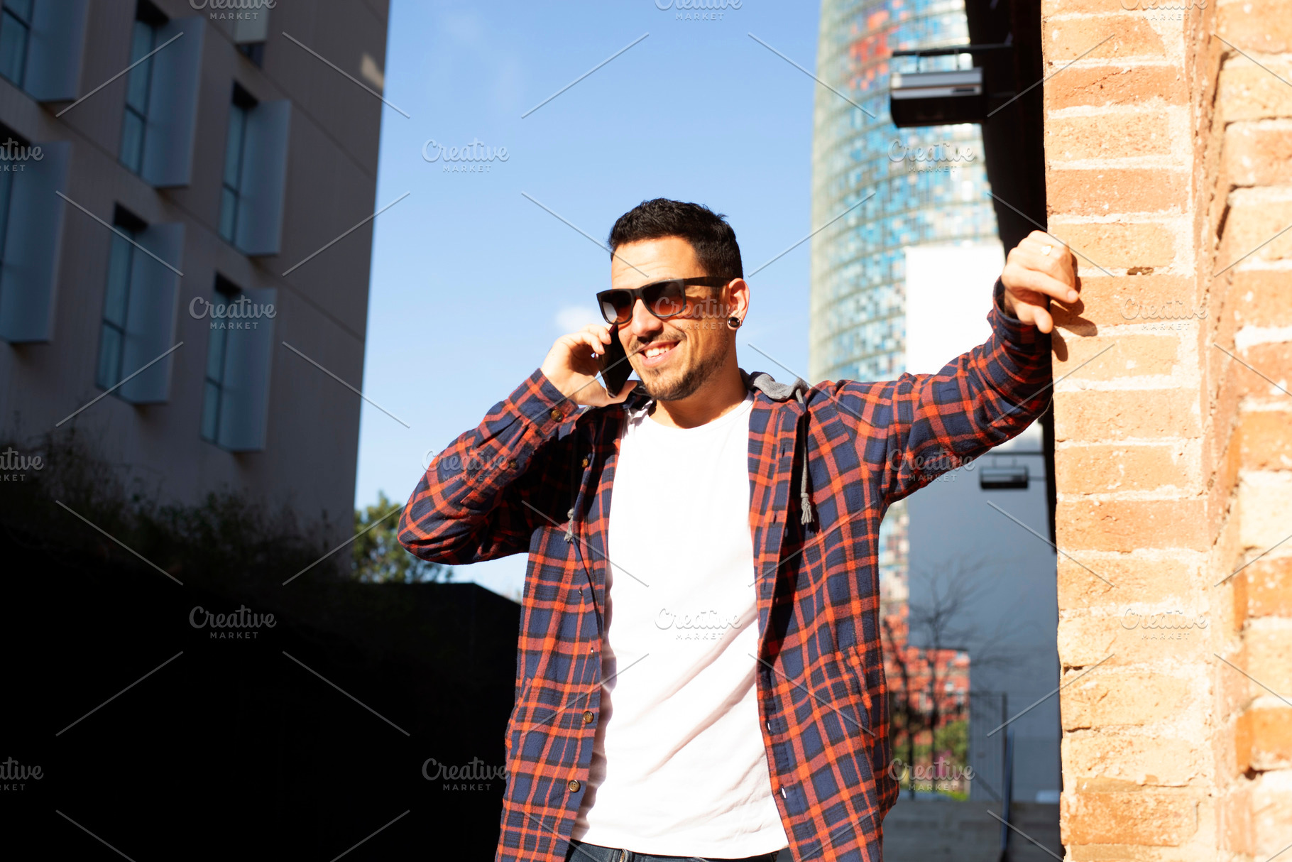 Caucasian man smiling on phone call in modern city street, a Person Photo by RF Images