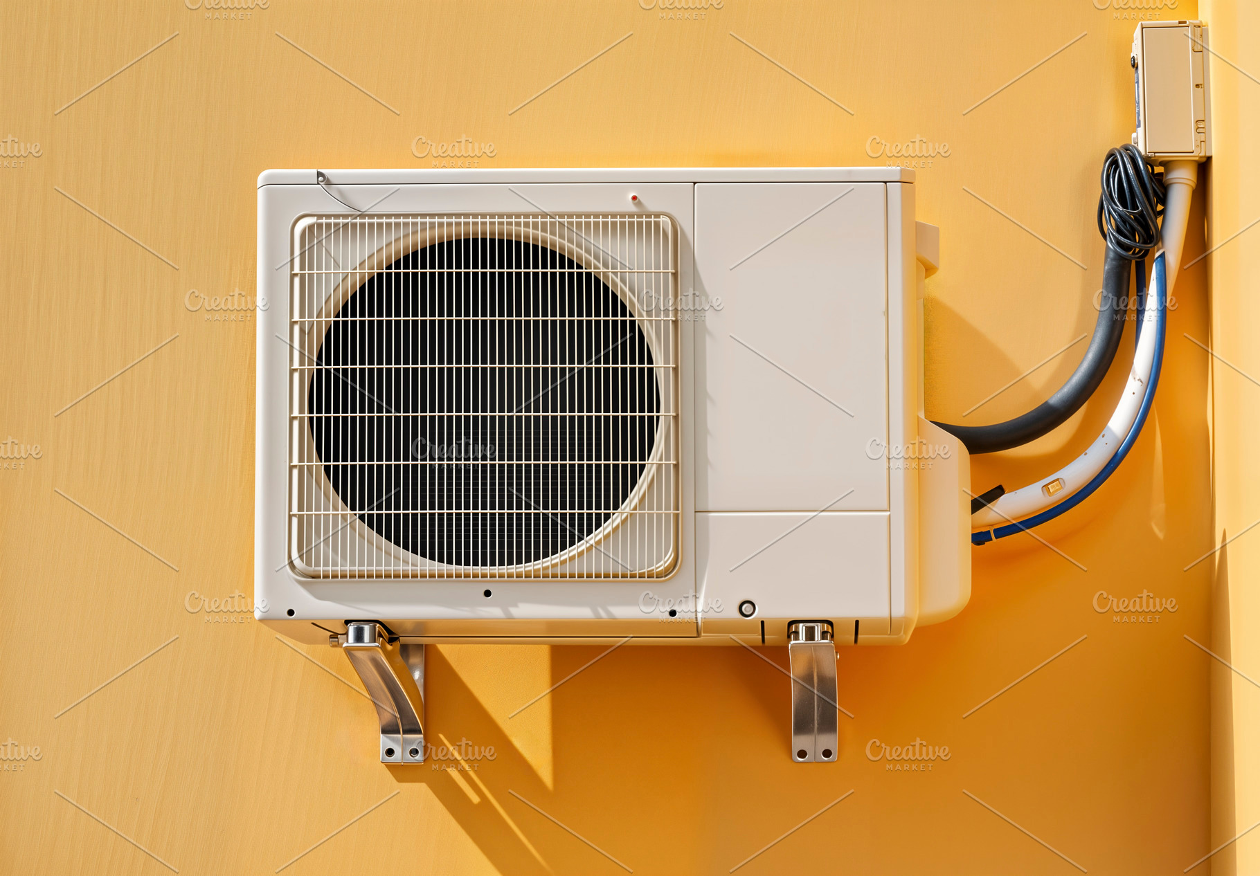 Air conditioning unit on yellow wall, a Photo by rarrarorro