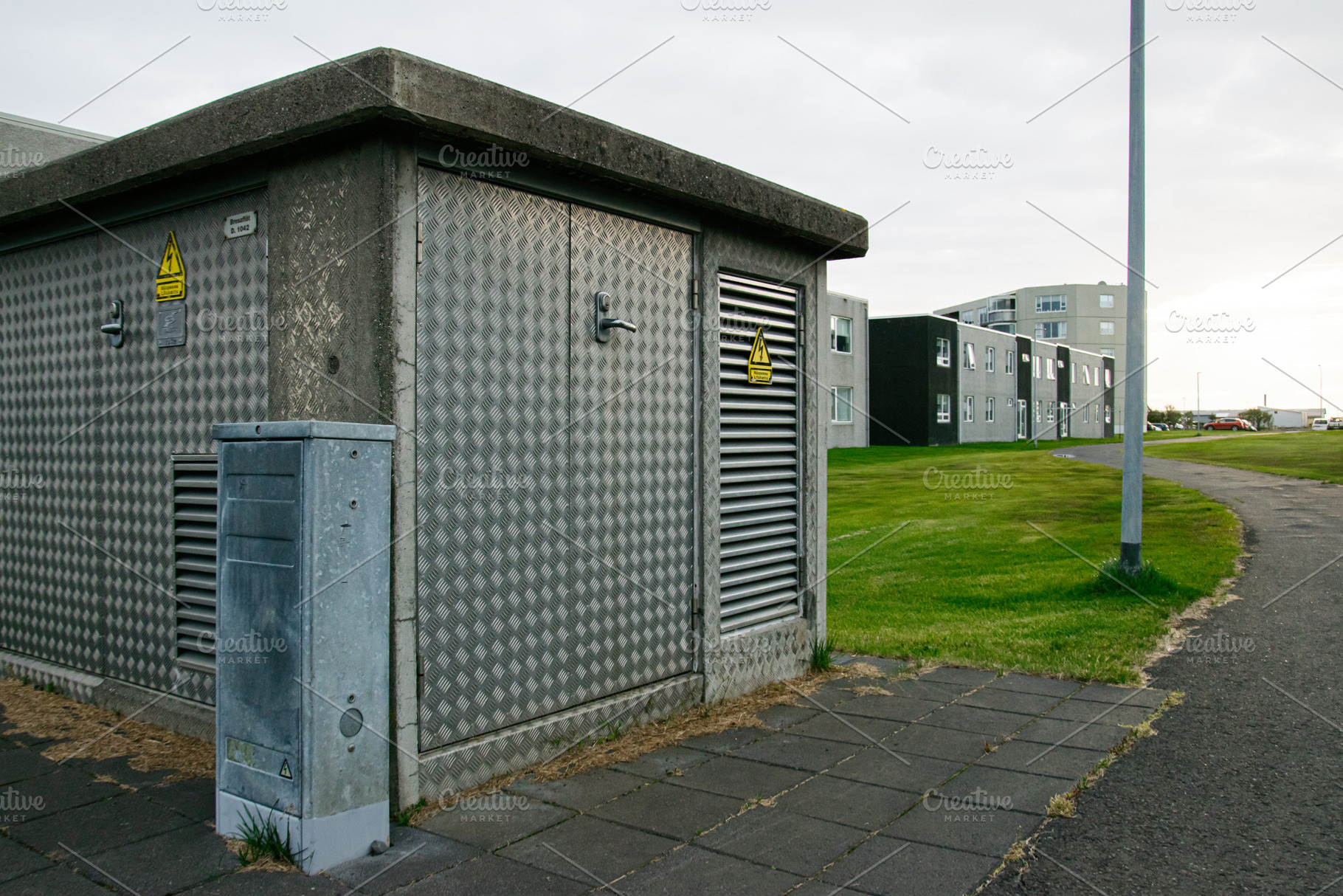 Metal-clad electricity utility building near modern residential housing in Akra, a Photo by AS photostudio