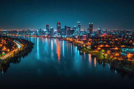 Night skyline: City lights reflectin, a Background Photo by Pixeness
