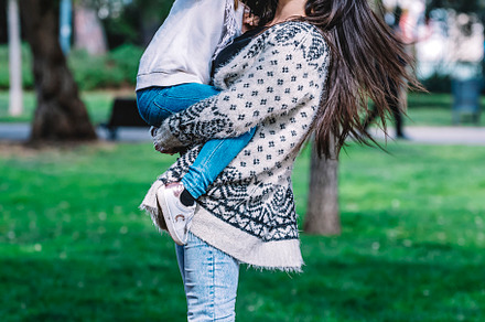 Mother holding her daughter and playing around park on beautiful morning., a Person Photo by 2Design