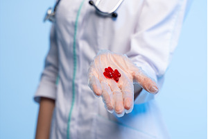 Doctor's gloved hand holding red, a Health & Medical Photo by volodymyrshtun13795