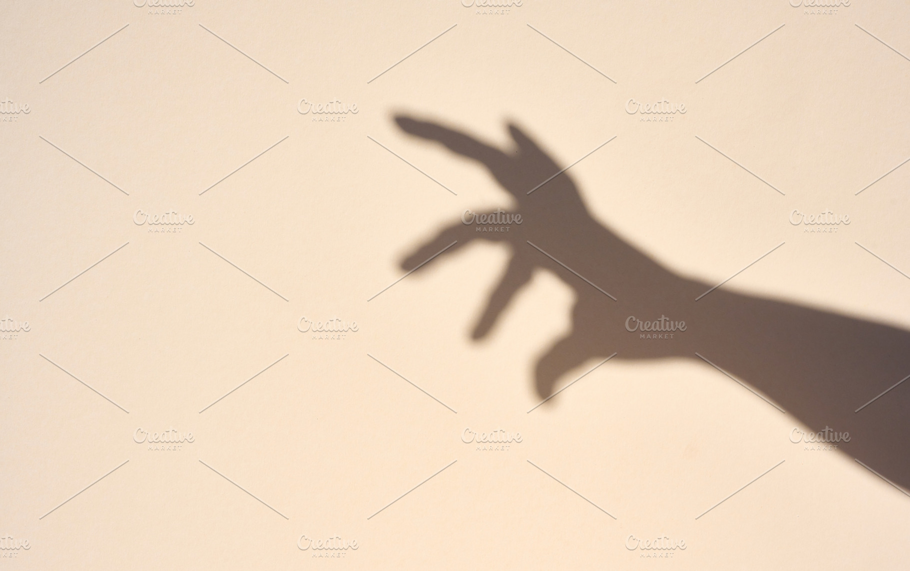 Sharp shadow of a hand on a light beige background., an Abstract Photo by ndanko