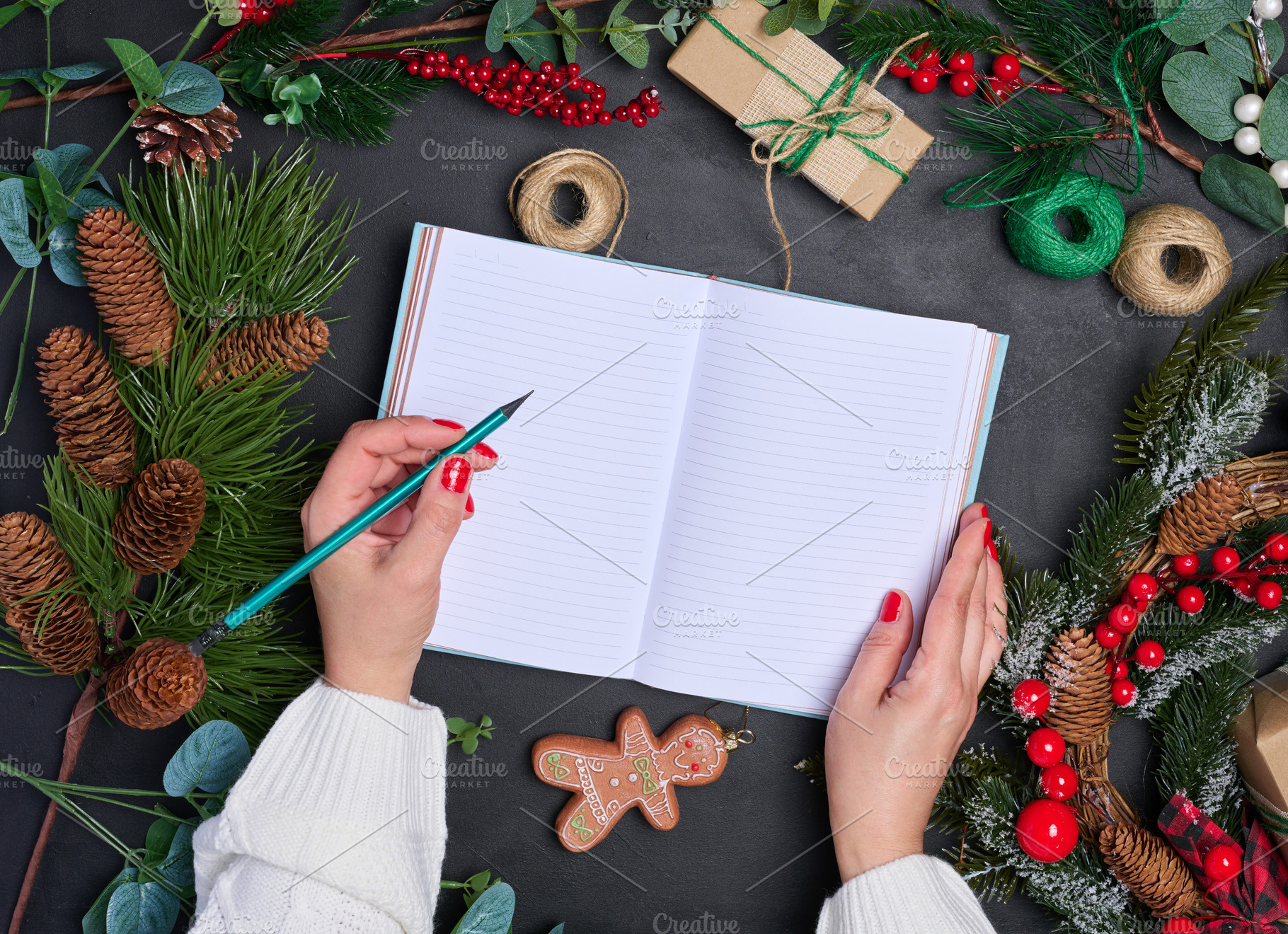 A woman sits at a table surrounded by Christmas decorations and, a Holiday Photo by ndanko