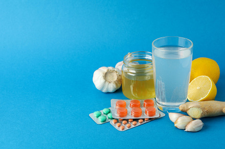Concept of treatment colds with honey and garlic on blue backgro, a Food & Drink Photo by AtlasStudio