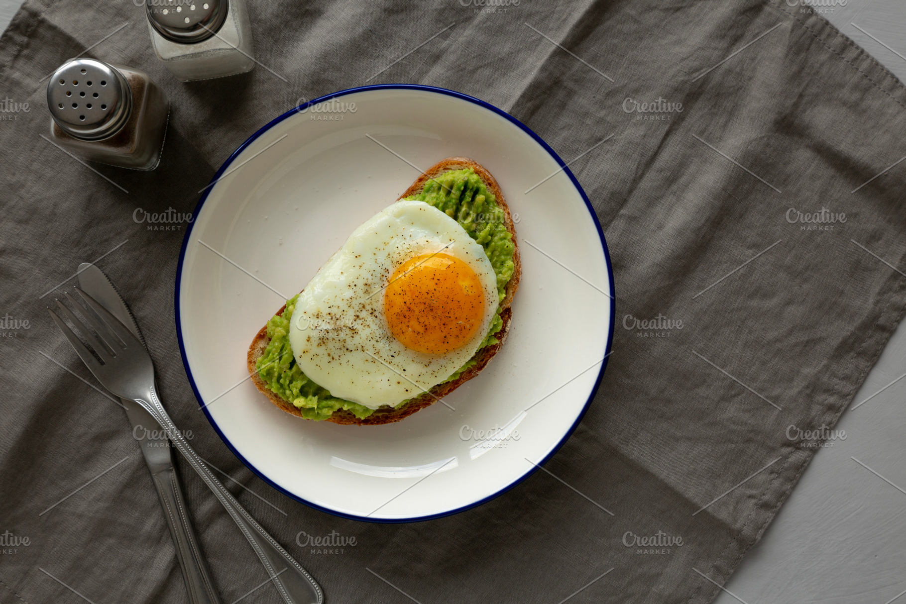Homemade Avocado Toast with Egg on a Plate, top view. Space for, a Food & Drink Photo by LiudmylaChuhunova