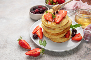 Stacked pancakes with strawberries, blackberries, and dripping h, a Food & Drink Photo by Olena Rudo