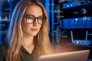 Professional female IT engineer (blonde woman in glasses) workin