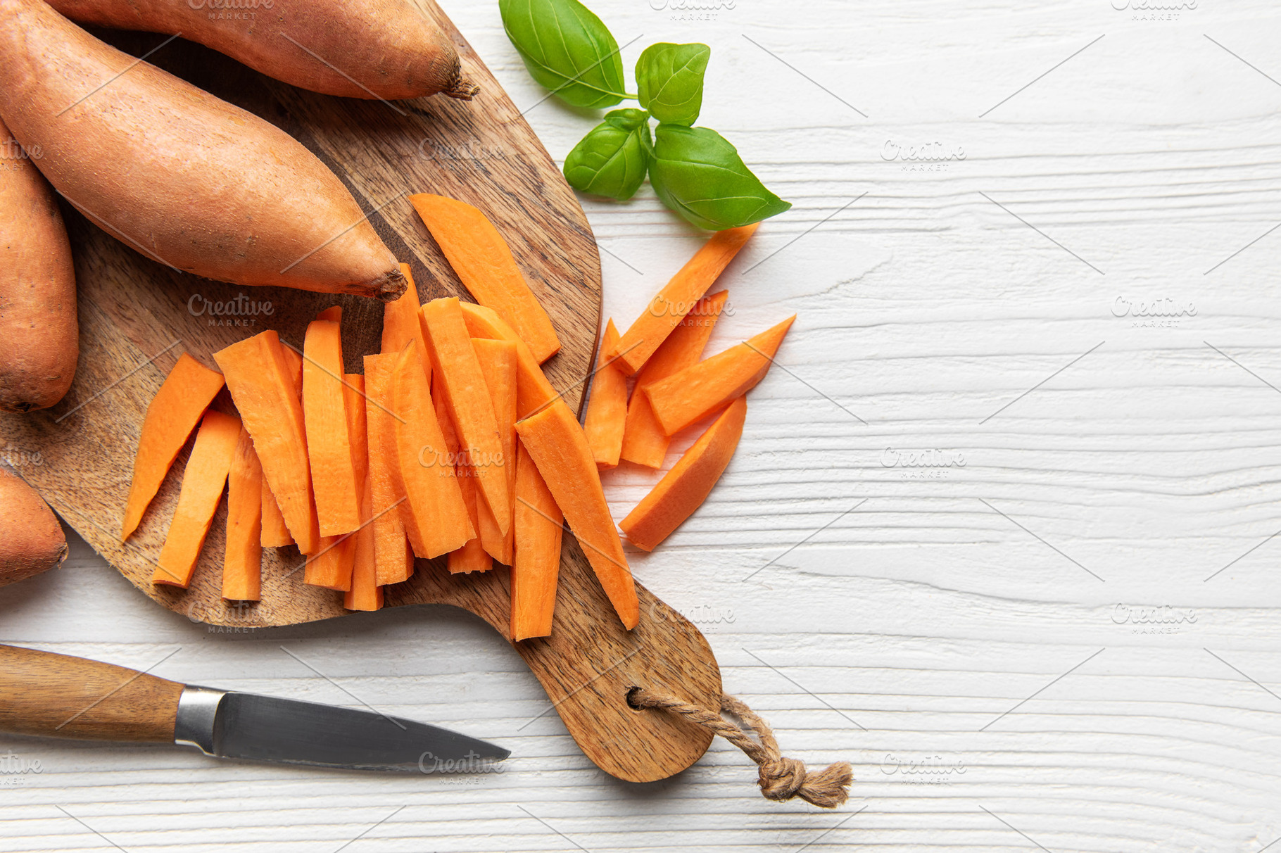 Sweet potato fries preparing on wooden cutting board, a Food & Drink Photo by Olena Rudo