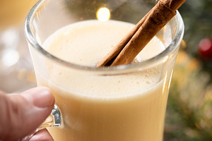 Hand picking up a glass of eggnog from a Christmas table, a Food & Drink Photo by etorres69