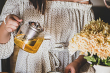 Young smiling woman pouring tea from stock photo containing young and woman