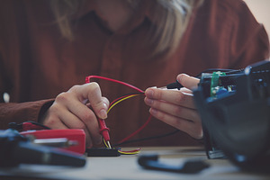 woman repairing electrical appliance at home