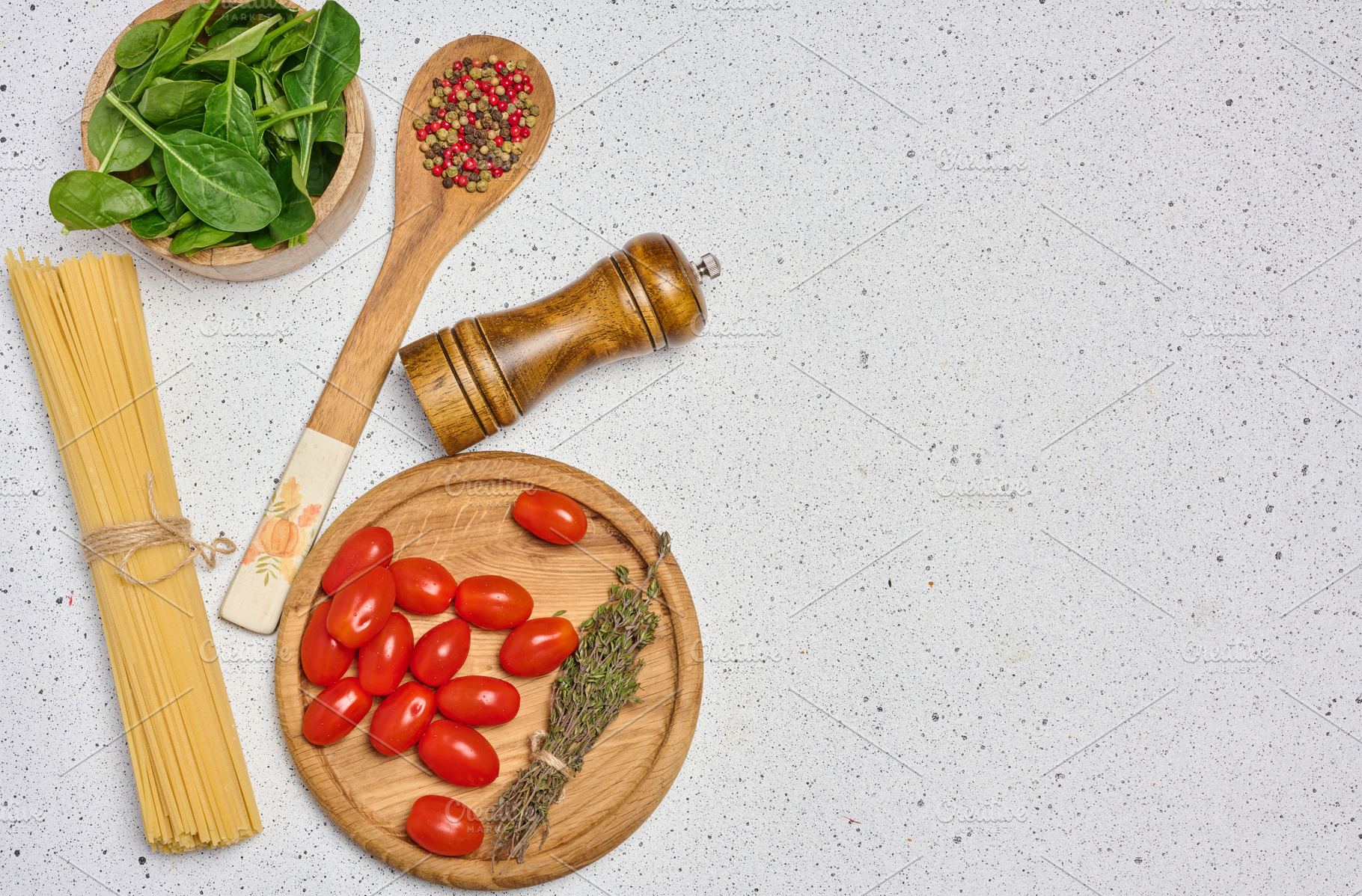 A flat lay shot of a wooden bowl with spinach, cherry tomatoes o, a Food & Drink Photo by ndanko