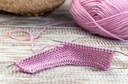 Knitting with needles and pink yarn skein on wooden background, horizontal, clo, an Arts & Entertainment Photo by iuliia_n
