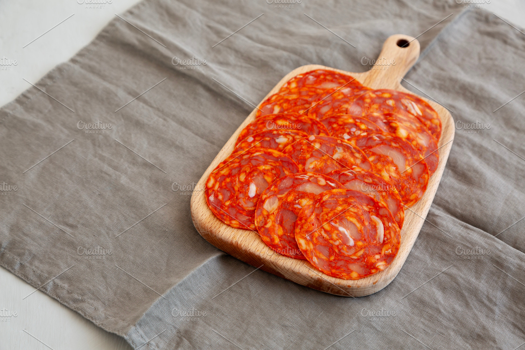 Cold Meat Chorizo Slices on a Wooden Board, side view. Copy spac, a Food & Drink Photo by LiudmylaChuhunova