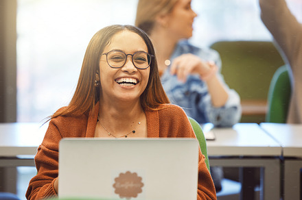 Black woman, laptop and student smile in classroom for university education, learning and school environment happiness. African girl, happy laughing and studying with digital tech device for college, a Photo by Peopleimages.com