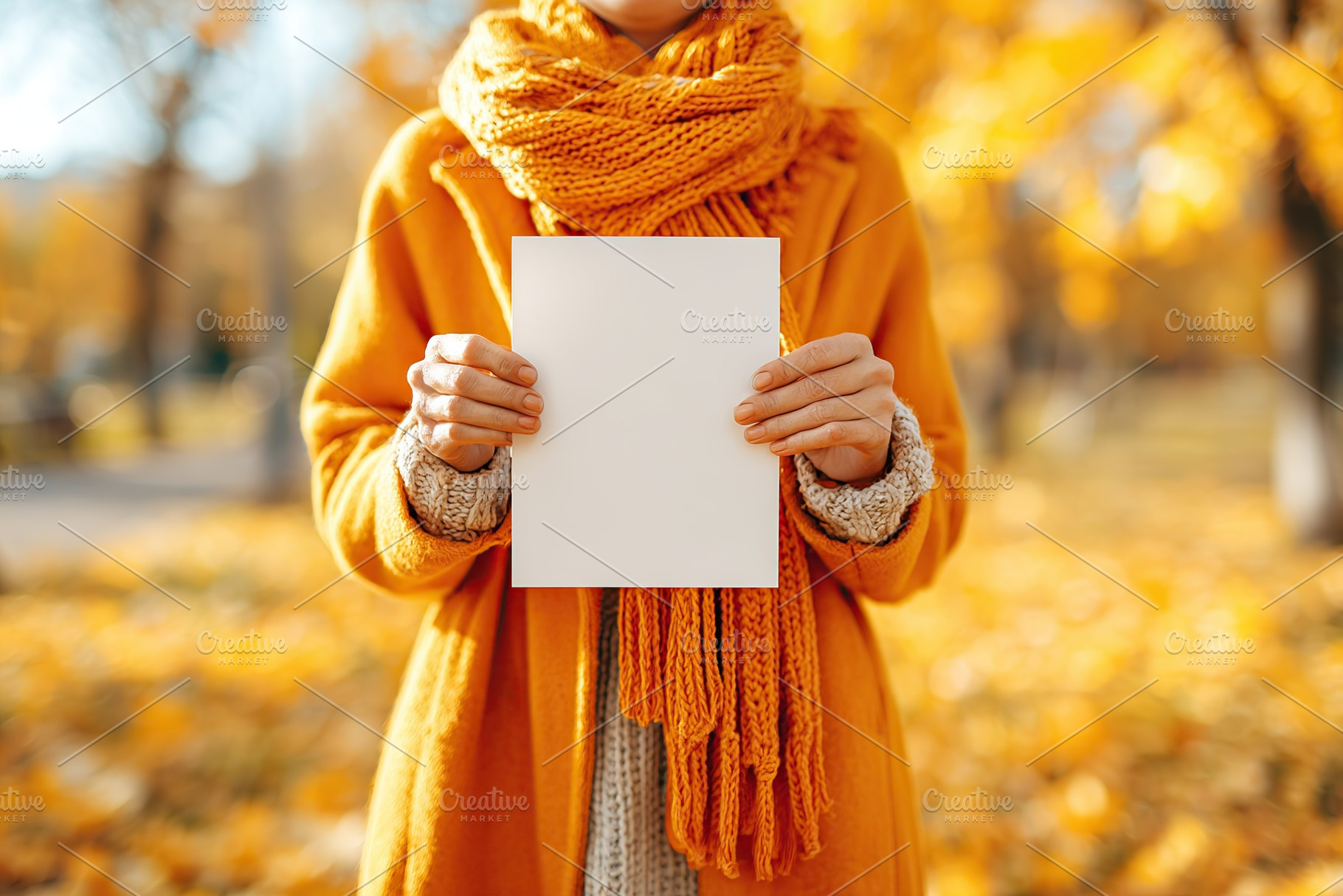 Individual holds blank vertical poster in a vibrant autumn park setting with co, a Photo by AlyaAnd