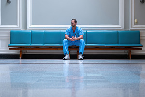 Man sits alone in hospital hallway, a Photo by Beautiful things