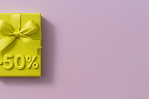Yellow gift box with ribbon and 50 percent sign on pastel pink b, a Photo by Dvoevnore photos