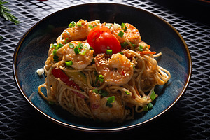 Noodles with Shrimp and Vegetables on Dark Plate on Black Table,, a Photo by MDBildes