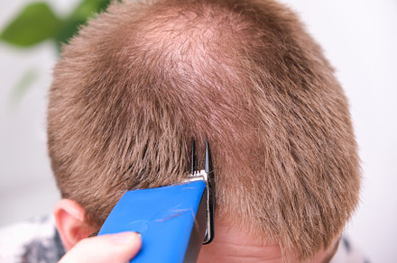 A man cuts his hair with clipper. Cutting a short hairstyle at home. Close-up., a Technology Photo by Detriana