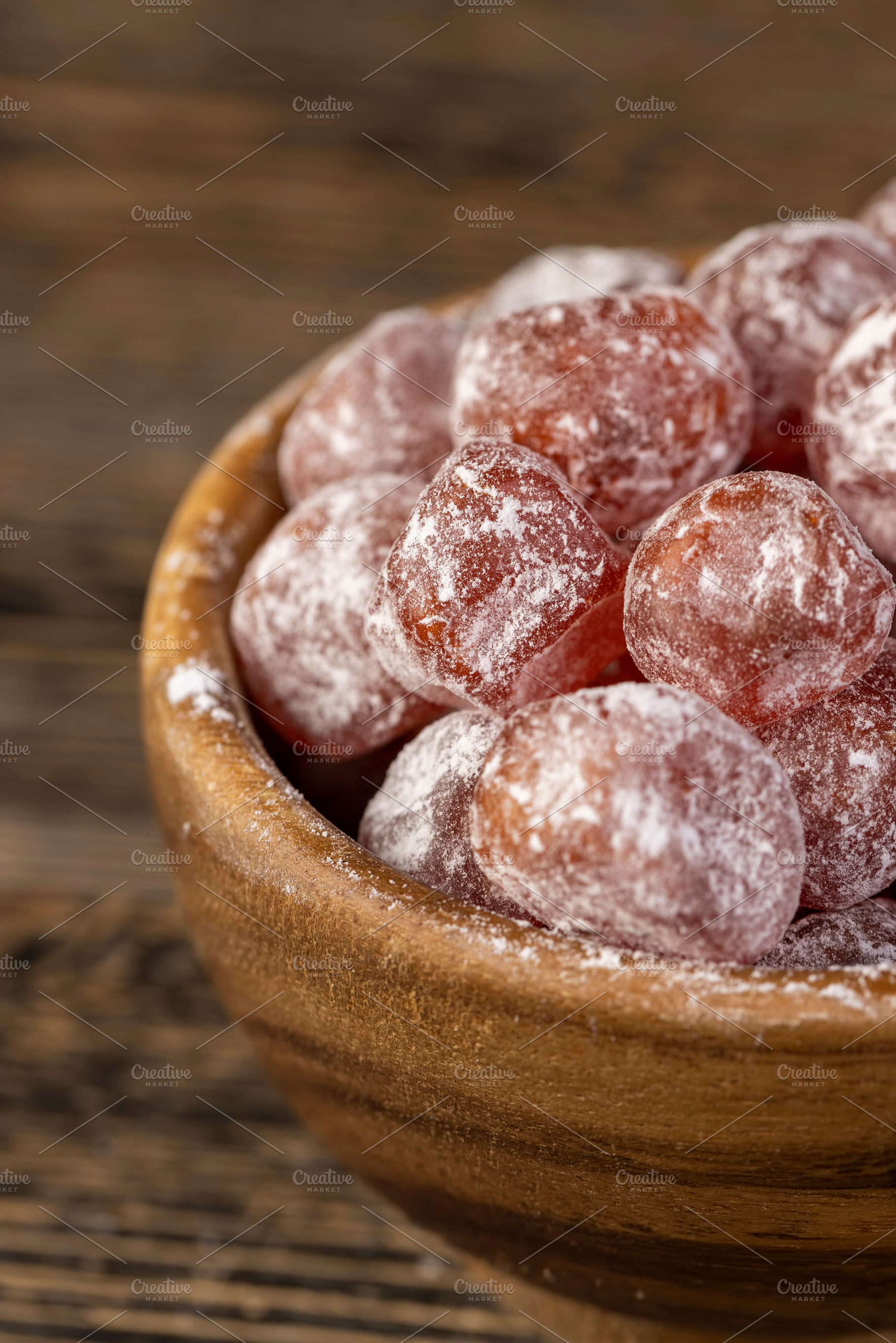 sweet dehydrated candied fruits of kumquat in white powdered, close up in a bow, a Photo by rsoollAI