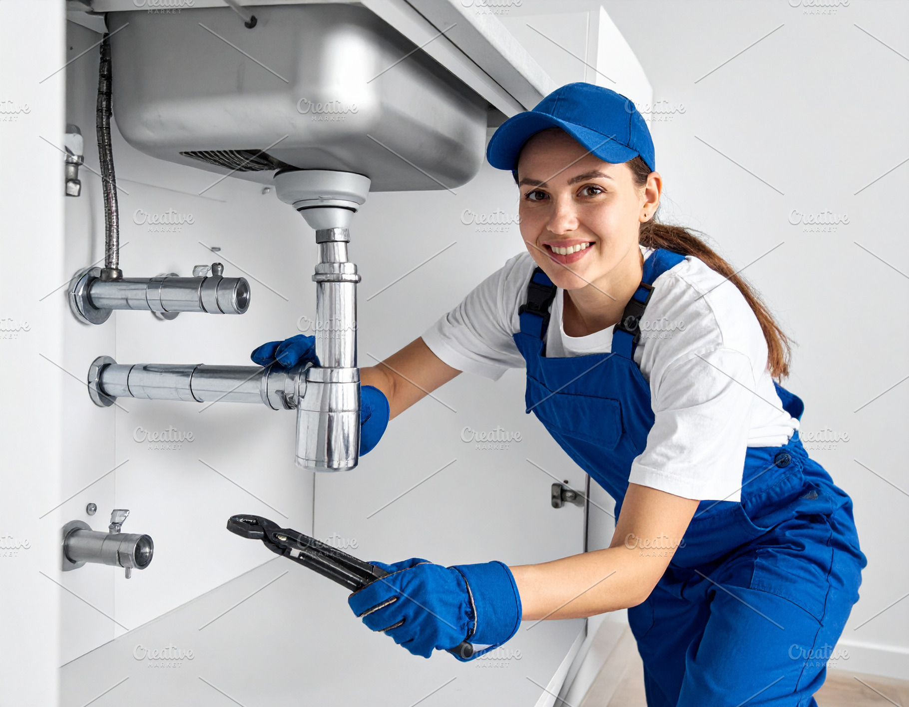 Man plumber fixing pipes under a sink., an Industrial Photo by DanFLCreativo
