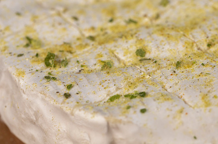 white soft cheese in salt and spices and small red round tomatoes on the table