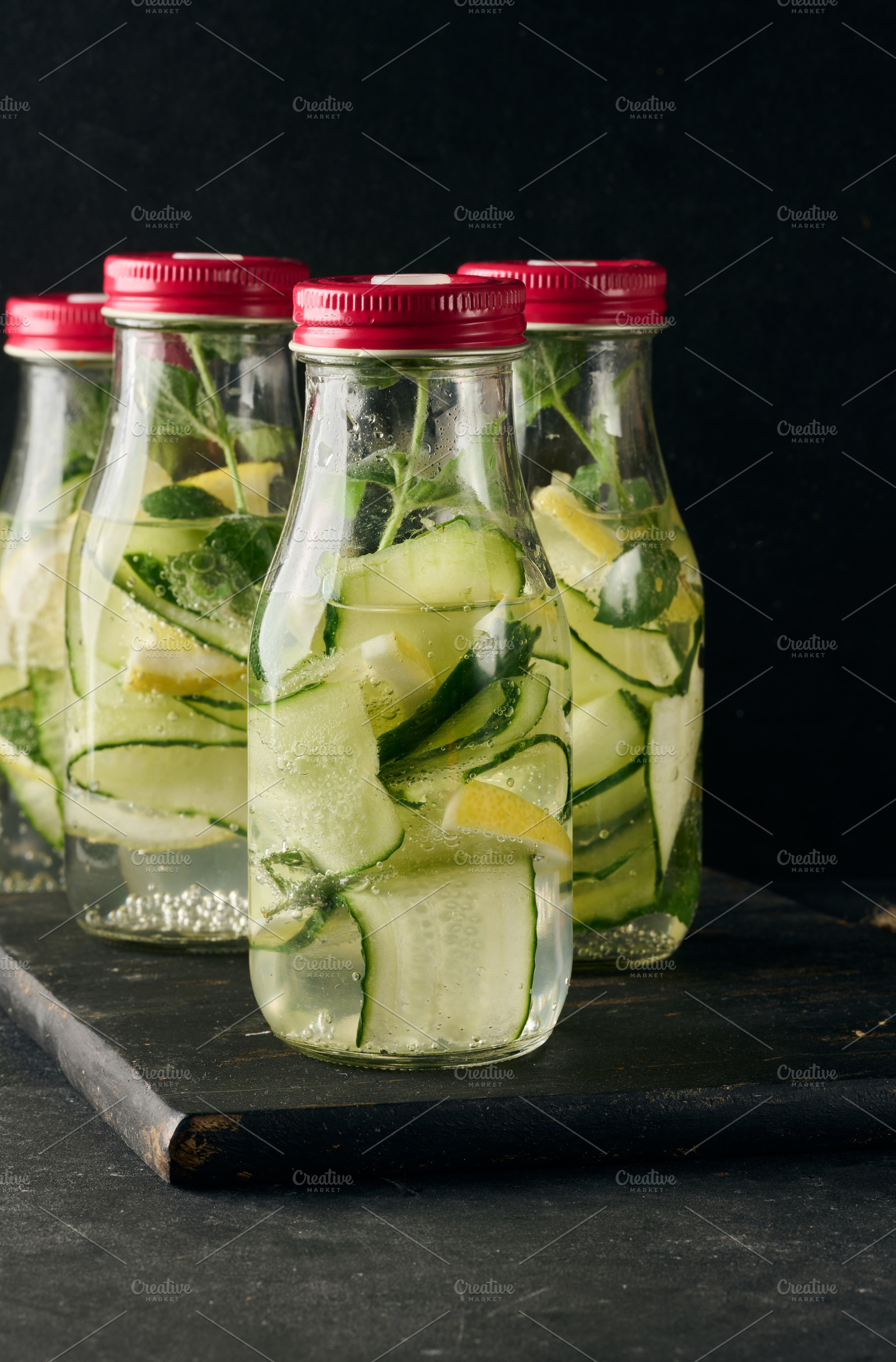 Gass bottles with red lids filled with detox water containing cu, a Food & Drink Photo by ndanko
