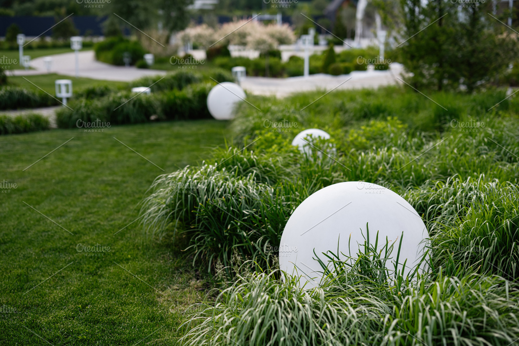 Beautiful landscaped garden with decorative white balls and pathways, a Photo by AS photostudio