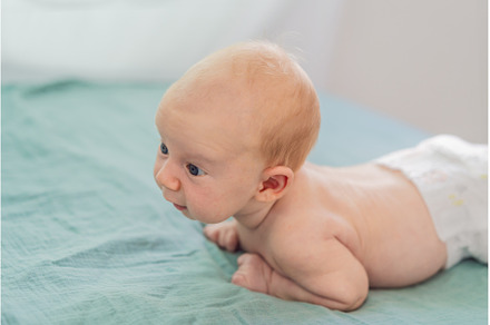 One-month-old baby lying on tummy