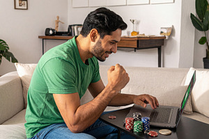 Happy man winning online casino on laptop, a Sports & Recreation Photo by Davizro's Market