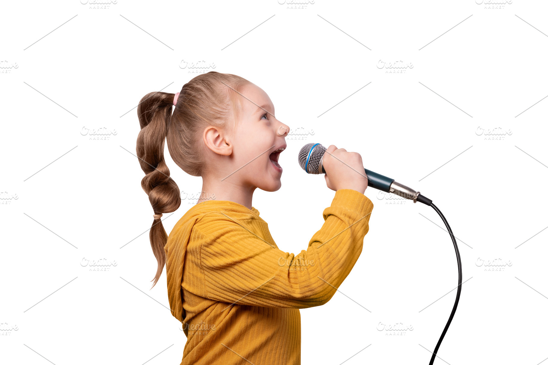 Joyful young girl in a yellow sweater singing into a microphone, a Person Photo by Ales Munt