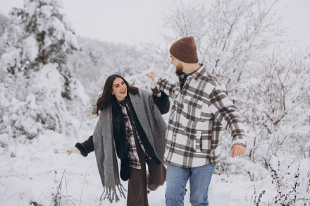 A young happy and loving couple walking in a snowy forest in the, a Person Photo by Cherkas Photography