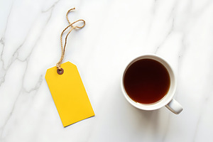 Bright yellow tag and coffee cup on, an Industrial Photo by Artonix