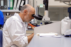 Researcher in a laboratory observing, a Health & Medical Photo by Perpis