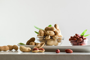 Peeled and unpeeled peanuts in glass bowls isolated on plate, a Food & Drink Photo by Davizro's Market