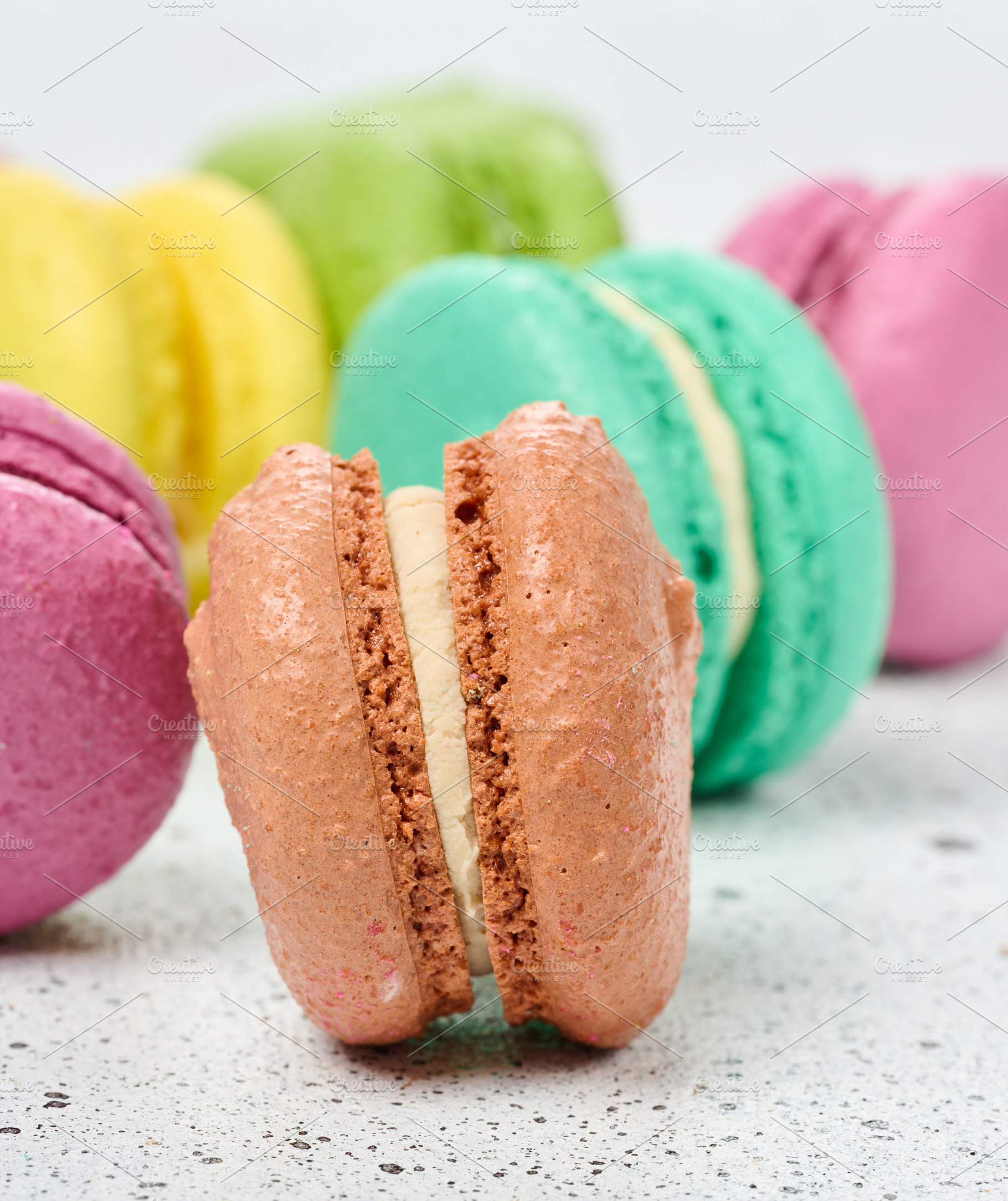 An assortment of colorful macarons on a white surface with dark, a Food & Drink Photo by ndanko