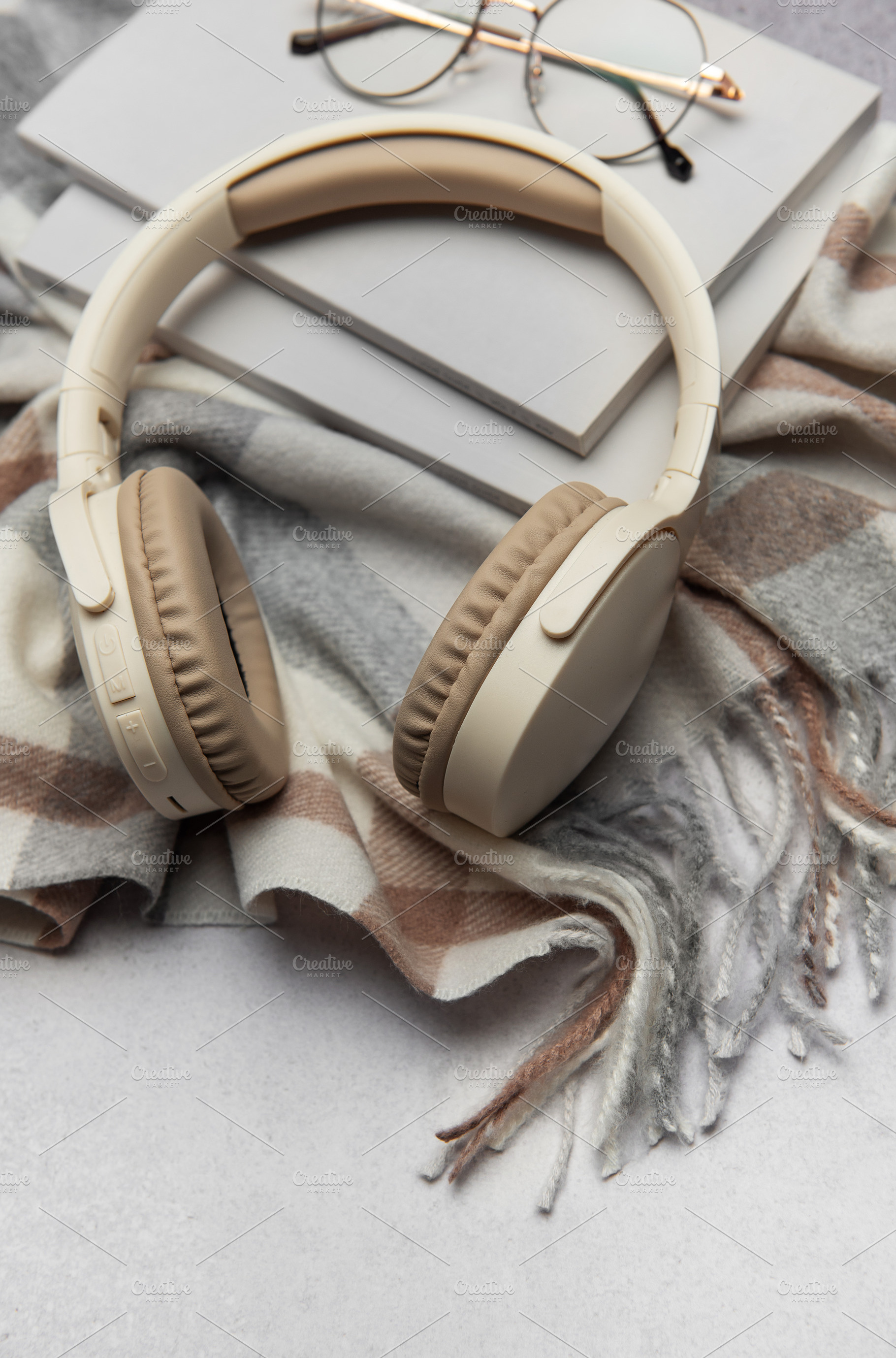 Warm plaid, headphones, book, and eyeglasses creating cozy atmos, a Business Photo by Olena Rudo