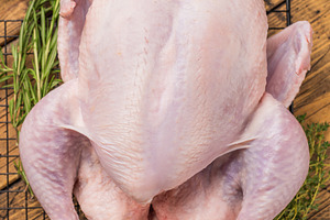Whole fresh raw chicken on a cooling rack with rosemary and thym, a Photo by composter-box@mail.ru